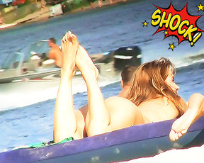 Two Naturists Drifting on an Inflatable Lake Raft