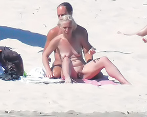 Three Nudists Gathered Near an Orange Windbreak