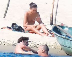 Checking Phone Topless Beside a Moored Wooden Boat