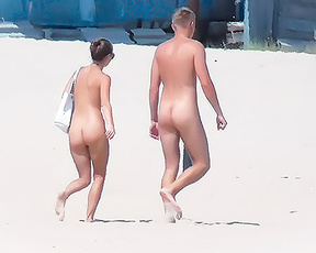 Nudistický pár na procházce po otevřeném písku