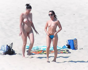 Twee vrouwen topless en bloot op een zandig topless strand