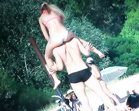 Three Topless Beach Bathers Playing by the Trees