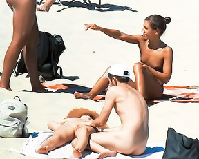 Four Nudists Gathered on Towels at a Nude Beach