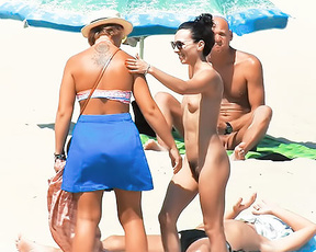 Four Naturists Gathering Beside a Blue Beach Umbrella