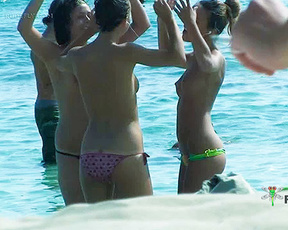Three Topless Women Wading in Clear Sea Shallows