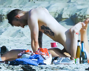 Nude Beach Couple Reclining Together Beside Wine Bottles on Sand