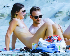 Couple at a Topless Beach Resting Against Pale Rocks