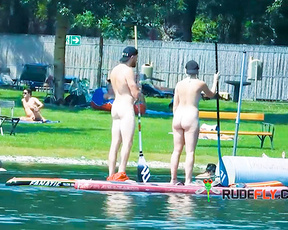 Paddleboarding Naturists Crossing a Calm Lake Swim Area