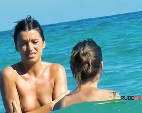 Due donne in topless nelle acque basse e turchesi