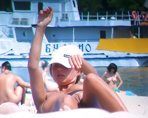 Sensual nude beach girl relaxes enjoys a sunny day