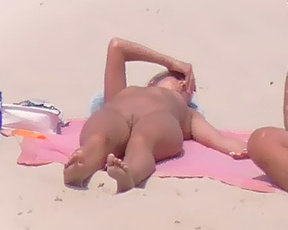 A mature naturist lady seemed very keen to hide her large beautiful breasts as she emerged from the sea.