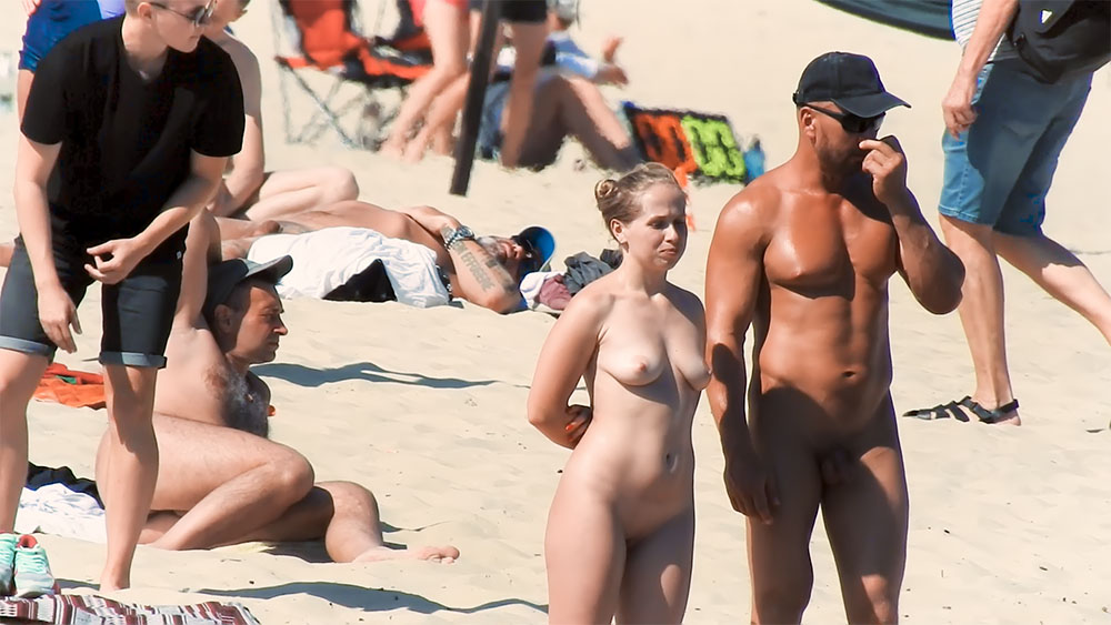 Dois nudistas a pausar na areia quente da praia