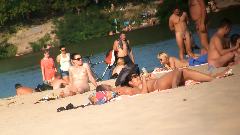 Reclining and Reading Among Nudists on a Riverbank