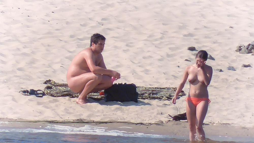 One Woman Topless on the Beach in Orange Bottoms