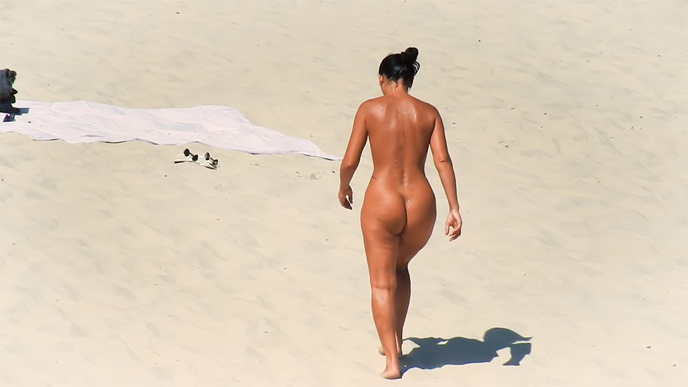 Nudist Beach Stroll Past a White Towel on the Sand