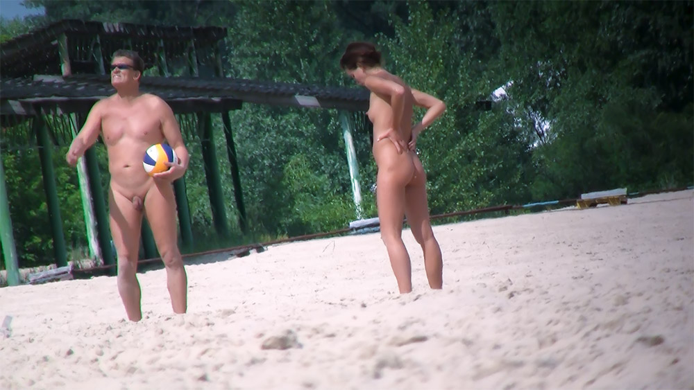 Two Nudists Playing Beach Volleyball on the Sand