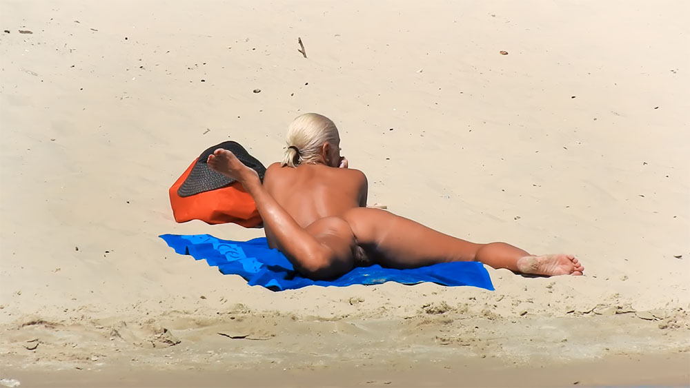 Nude Beach Towel Stretch Beside a Red and Black Bag