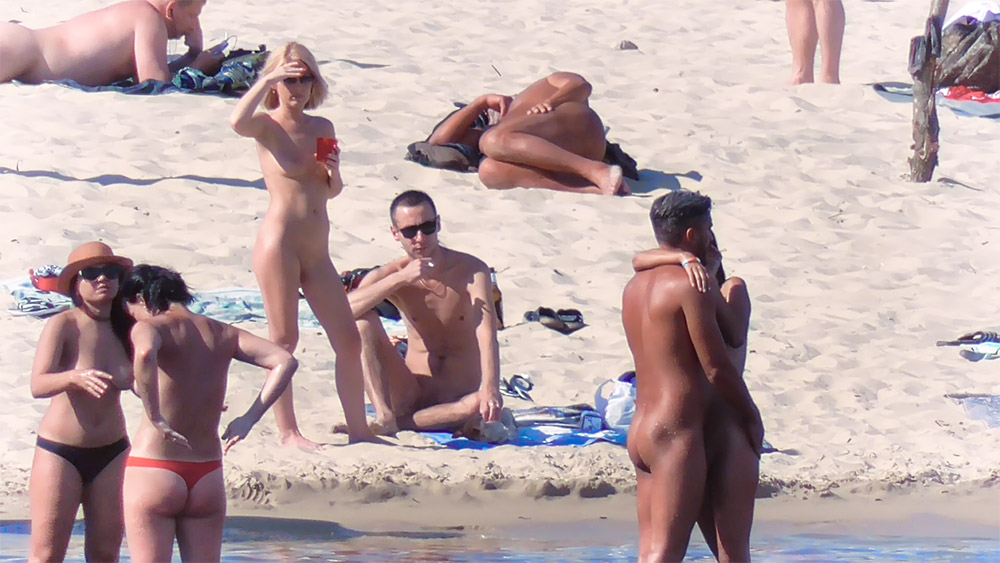 Naturisten verzameld op het zand langs de kustlijn