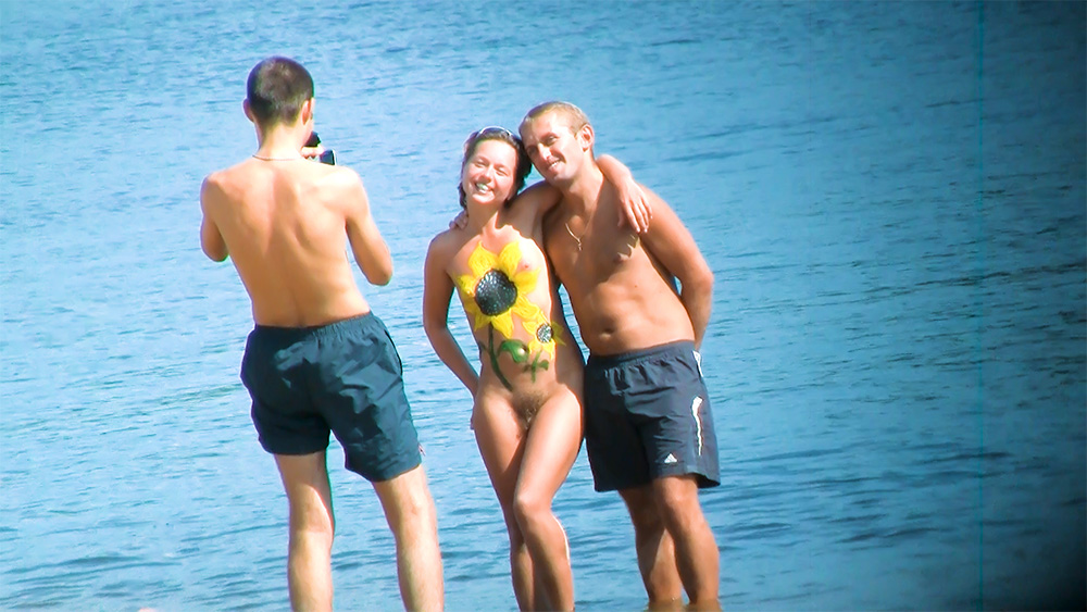 Tres naturistas reuniéndose en el lago para una foto