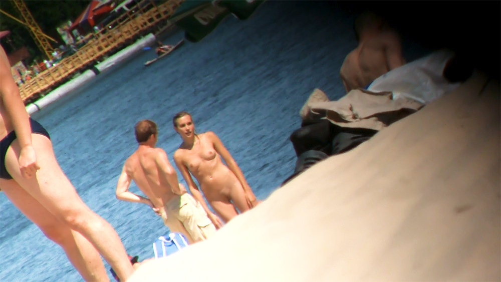 Two Nudists Pausing at the Water's Edge