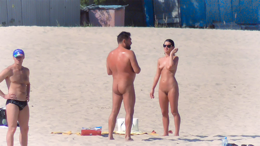 Para na plaży dla nudystów stojąca i rozmawiająca na piasku