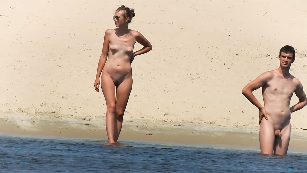 Stojąc na brzegu na cichej plaży dla nudystów