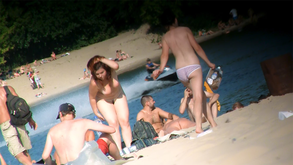 Red-Haired Nudist and Sunbathers Beside a Poolside Beach