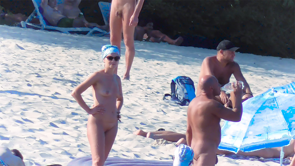 Chvíle na nudistické pláži s modrým šátkem a slunečními brýlemi