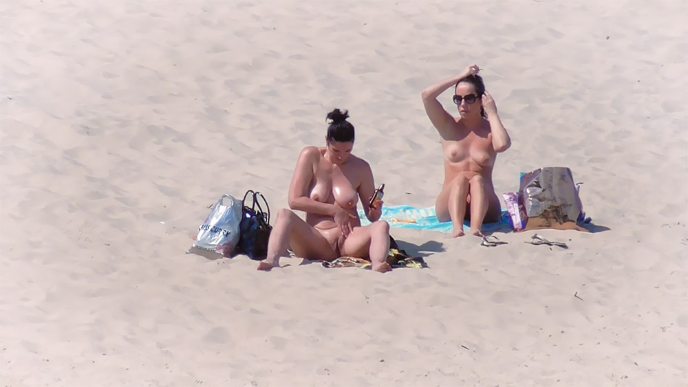 Sandy Nude Beach with Two Nudists Tying Hair Up