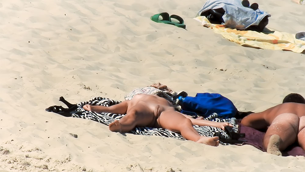 Zebra-Striped Towel and Blue Bag on a Nudist Beach