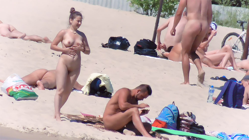 Quatro Naturistas a Partilhar o Espaço na Areia numa Praia Nudista Ensolarada