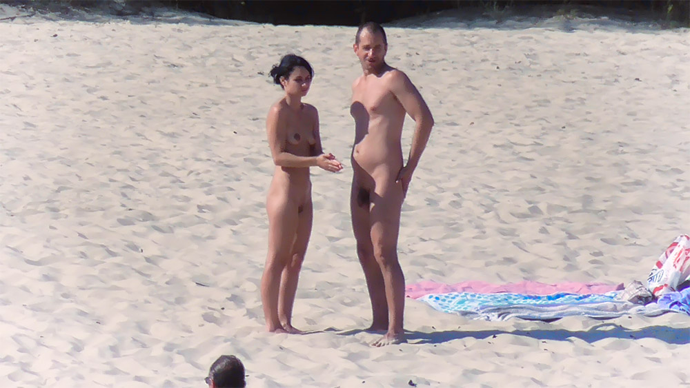 Naaktstrand-koppel pauzeert op open zand