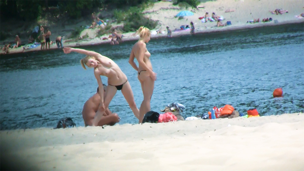 Ongedwongen strandplezier – blonde naturisten aan de oever