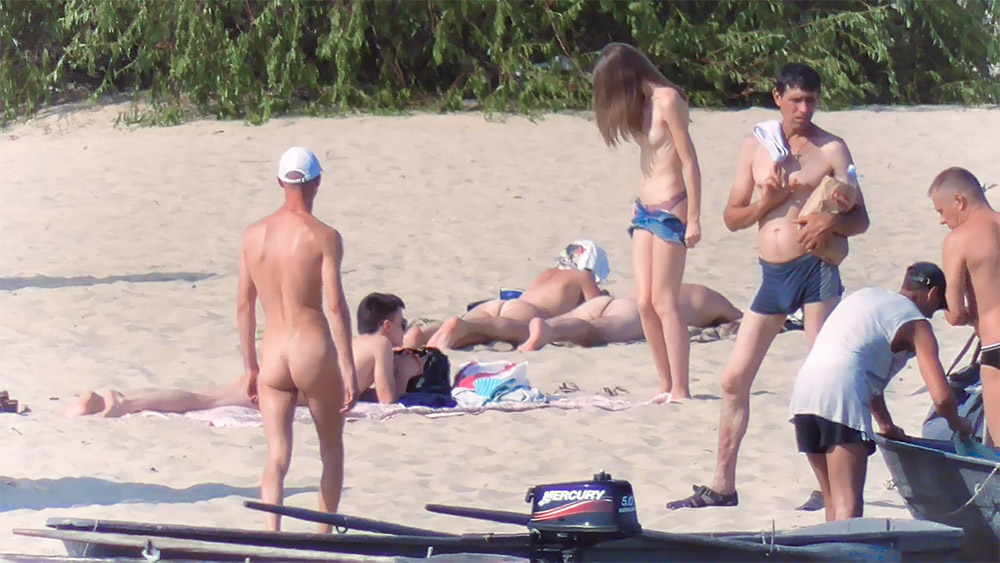 Čtyři naturisté na teplém písku pláže