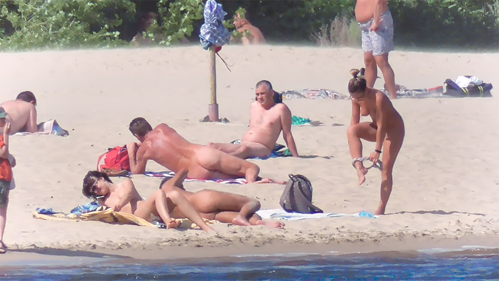 Four Nude Beach Visitors Settling on the Sand