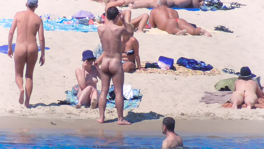 Tři naturisté odpočívají na slunečné pláži