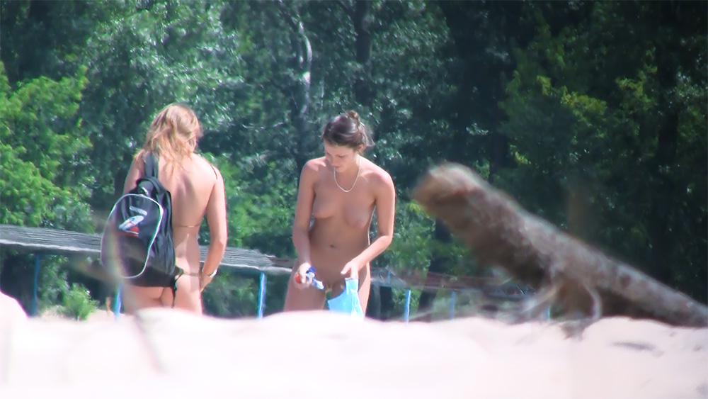 Three Naturists Pausing Near a Wooded Riverside Spot