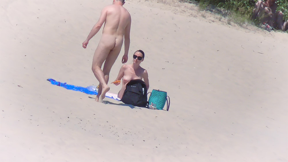 Nude Beach Couple Settling Onto a Blue Towel