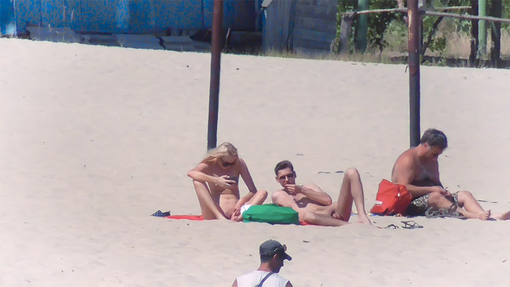 Lugar de Praia com Guarda-Sol de Poste e uma Banhista em Topless