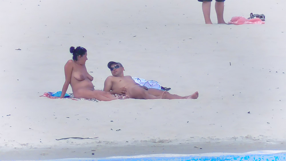 Nude Beach Couple Sitting Together on Pale Sand