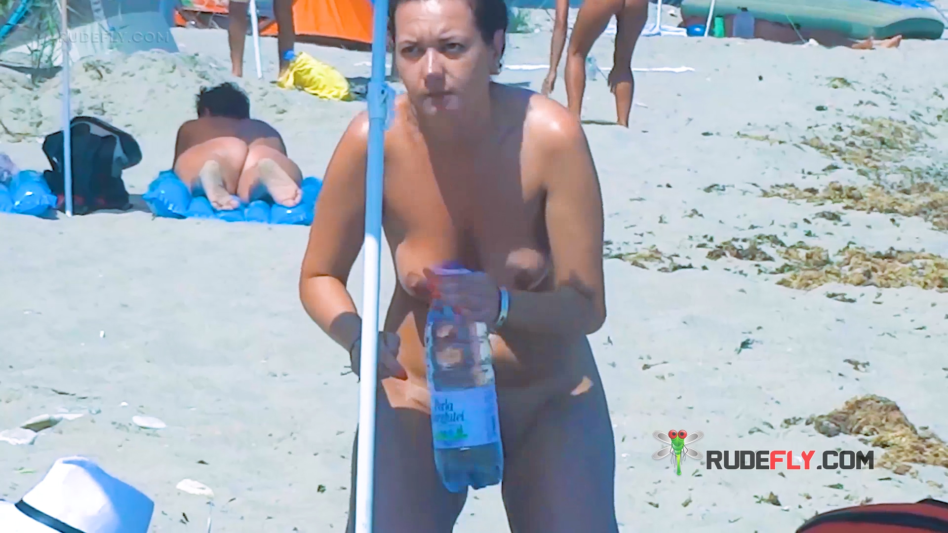 Parasol Shade and Water Bottle on a Nudist Beach