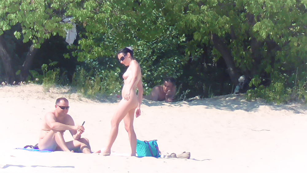 Troje nudystów odpoczywających przy turkusowej torbie plażowej