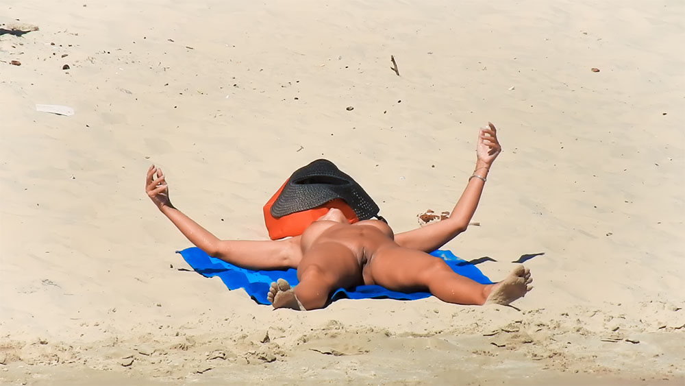 Sunbathing Face Down on a Blue Towel at a Nude Beach