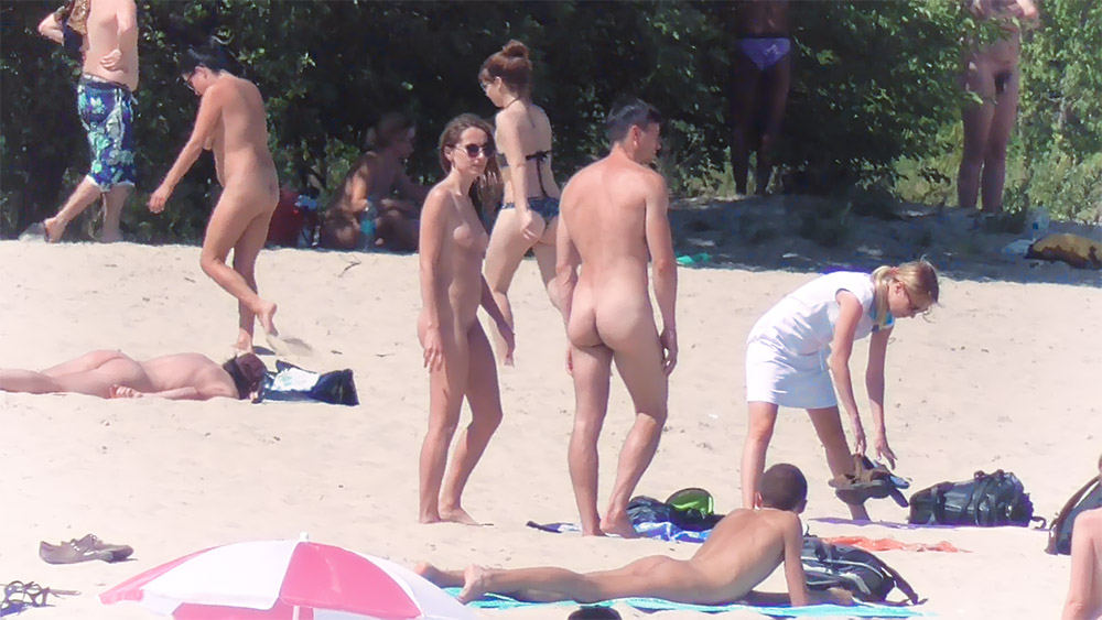 Five Naturists Gathered on a Bright Sandy Beach