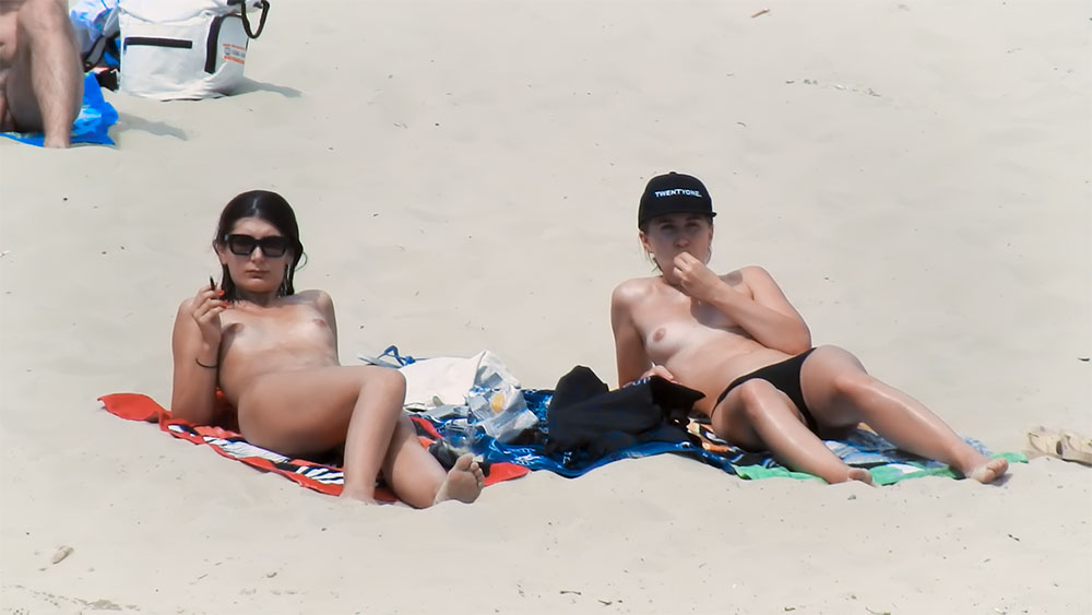 Détente sur une serviette rouge sur une plage naturiste
