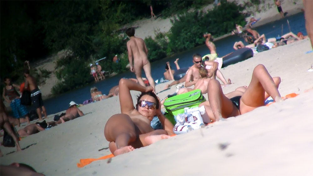 Two Nude Beach Sunbathers Resting on the Sand