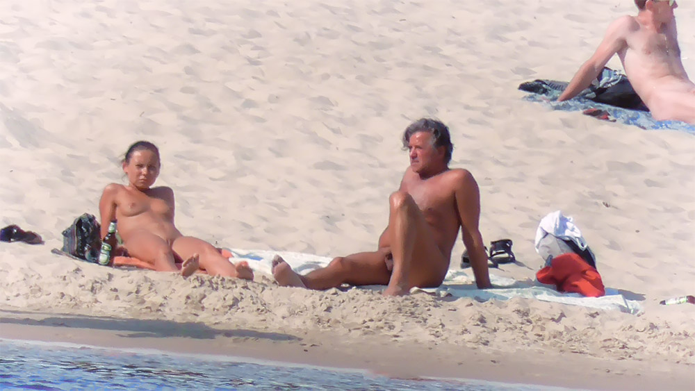 One Nudist Leaning Back Beside a Beach Backpack