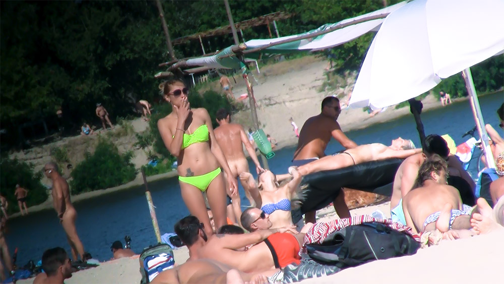 Standing in a Neon Bikini Among Riverside Naturists