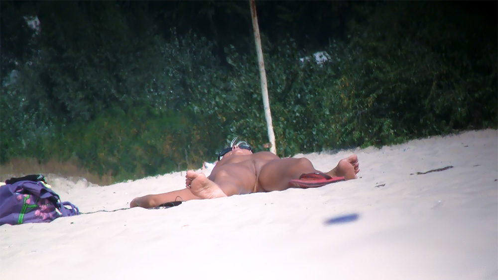 Nude Beach Sunbather with Red Towel Beside Greenery