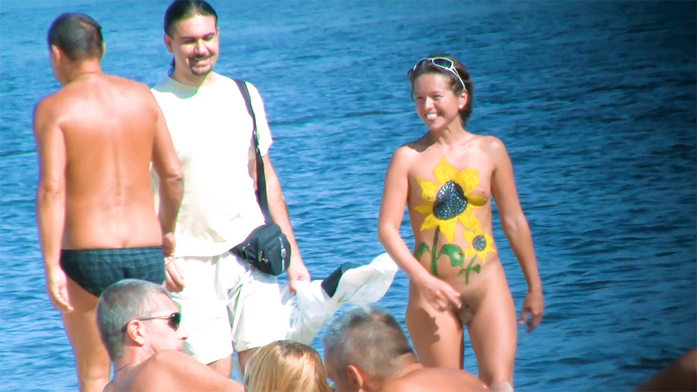 Nudists with Sunflower Body Art on a Sunny Lakeside Beach